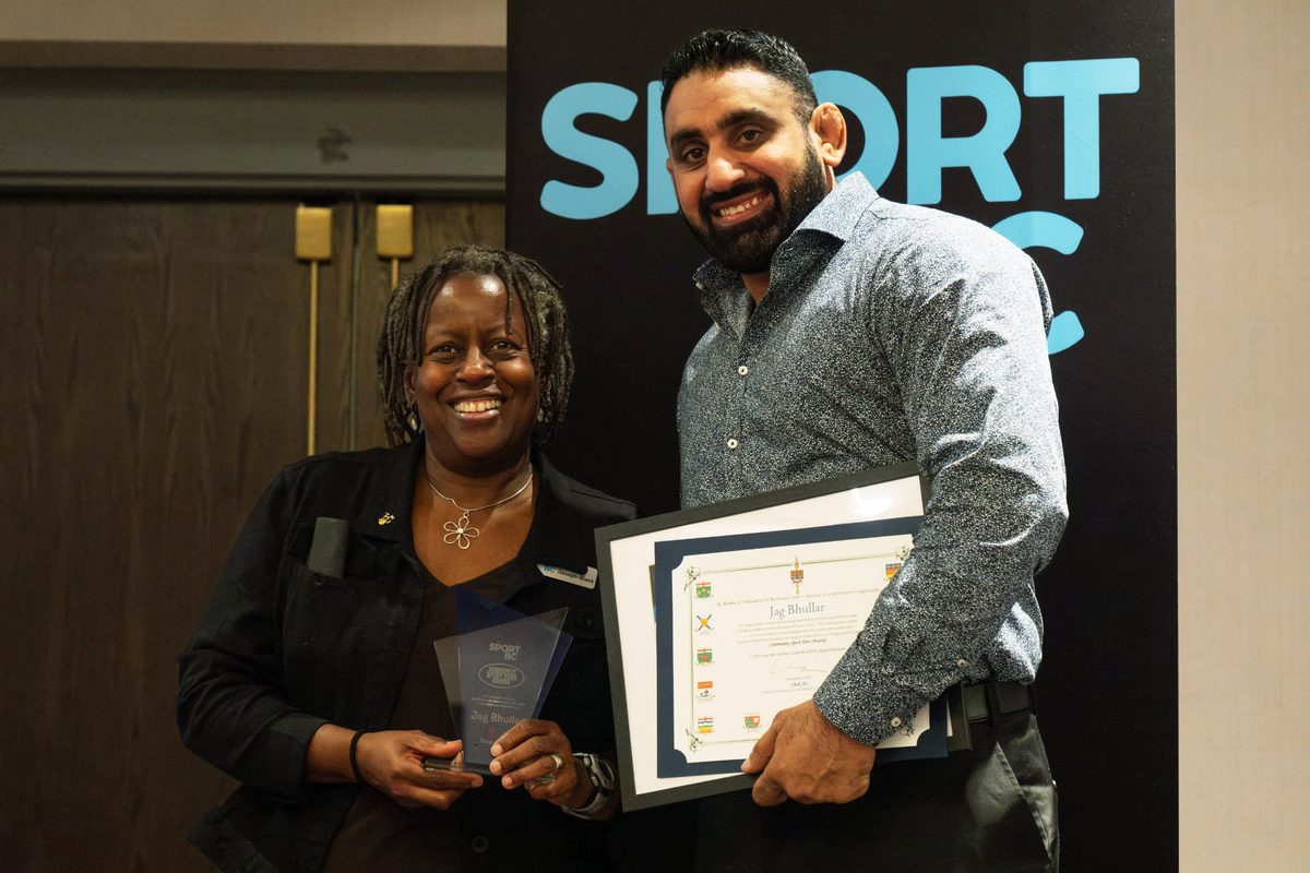 Coach Jag receiving Sport BC Sport Hero Award with presenter
